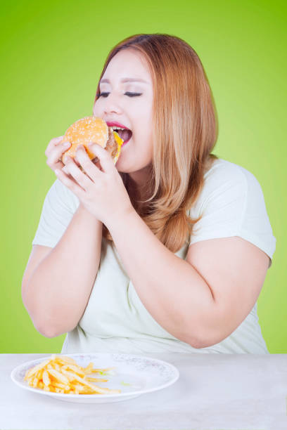 istock Beautiful blonde woman eats hamburger 639803354