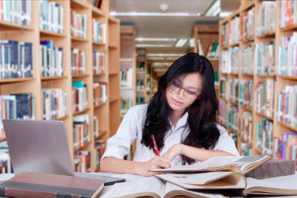 istock Attractive student with long hair studying in library 639803876