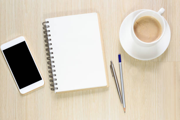 istock Blank notepad on office desk with smartphone, coffee cup 639809714