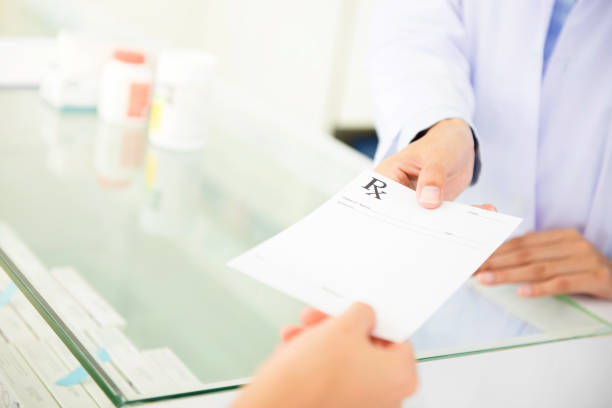 Customer (patient) giving prescription to pharmacist