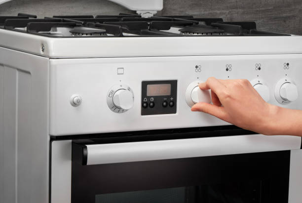 istock Female hand turning on white kitchen gas stove 639811412