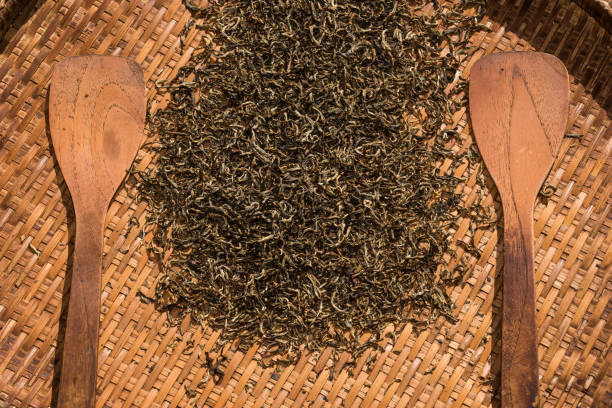 dry tea leaves in bamboo basket stock photo