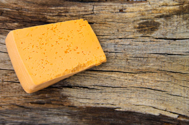 istock Piece of cheese on a wooden background 639817482