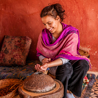 Moroccan woman producing argan oil by traditional methods. Argan oil is a plant oil produced from the argan tree that is endemic to Morocco. The argan oil is used for cosmetic purposes