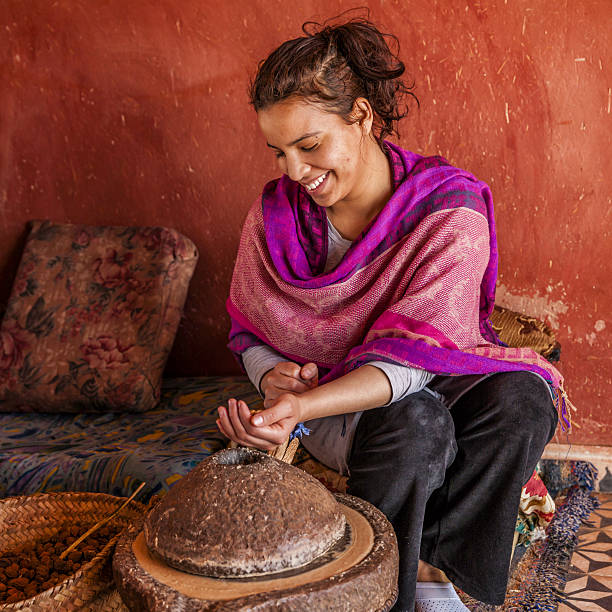 moroccan woman producing argan oil by traditional methods - berbere imagens e fotografias de stock