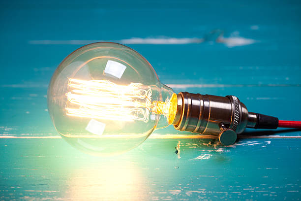 istock Vintage incandescent Edison type bulb on turquoise wooden table 639820492