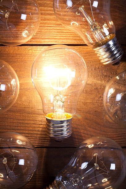istock Vintage incandescent bulbs on old wooden table 639820608