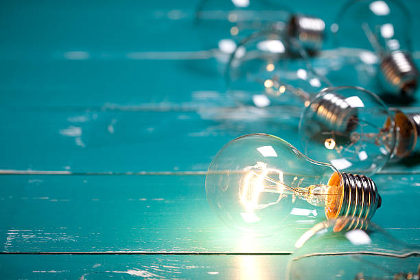 istock Vintage incandescent Edison type bulb on turquoise wooden table 639820758