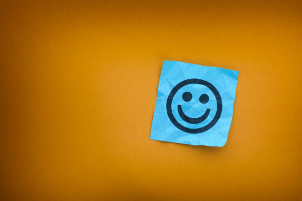 istock Blue paper note with happy face on a yellow paper background 639820920