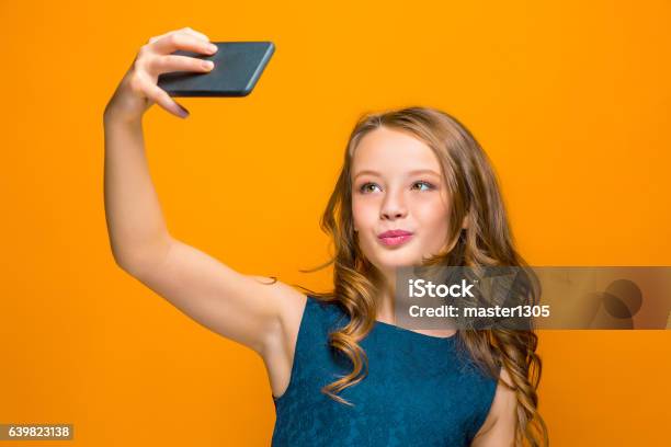 La Cara De La Chica Adolescente Feliz Juguetona Con El Teléfono Foto de stock y más banco de imágenes de Adolescente