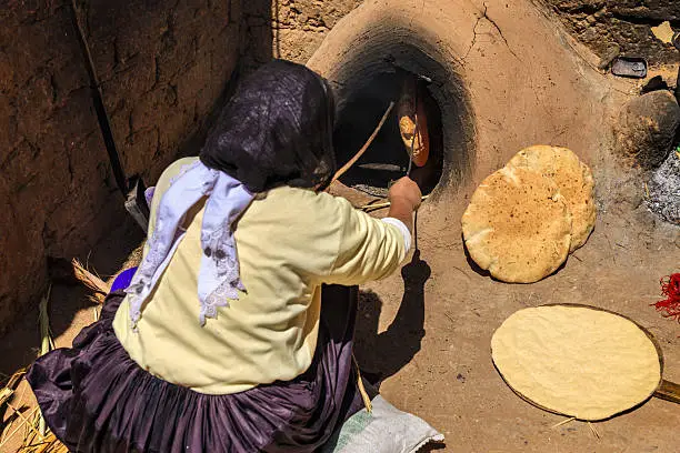Moroccan woman making bread (khubz) in traditional way.http://bhphoto.pl/IS/morocco_380.jpg