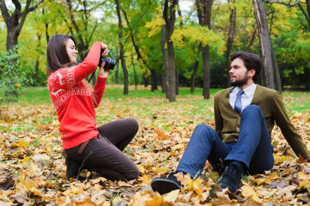 istock couple taking photos in autumn park 639826276
