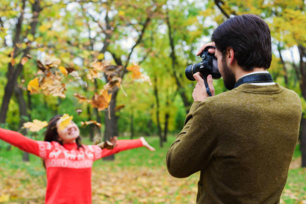 istock couple taking photos in autumn park 639826382