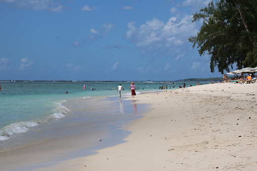 Flic en Flac, Mauritius - December 14, 2016: People enjoy the white beach in the western part of Mauritius during a beautiful day.