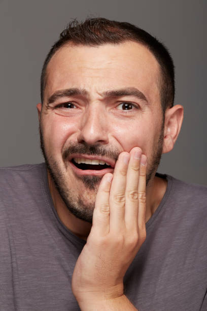 istock young man with a toothache tooth pain 639826572