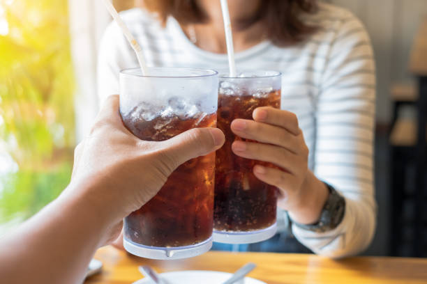 männer und frauen hand geben glas cola - soda stock-fotos und bilder