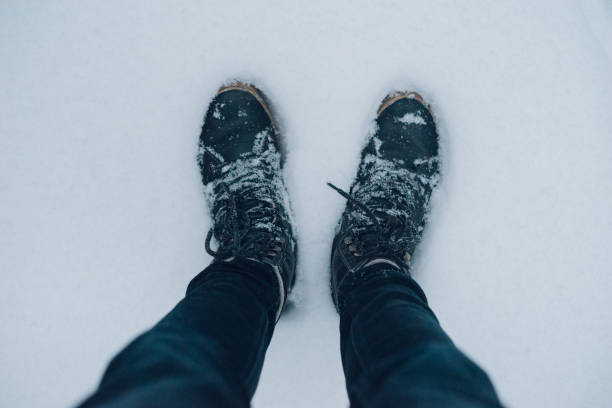 istock Male legs in winter boots on snowy surface 639829354