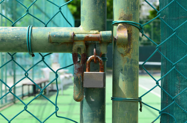 istock Rust lock at old green wire mesh fence 639832590