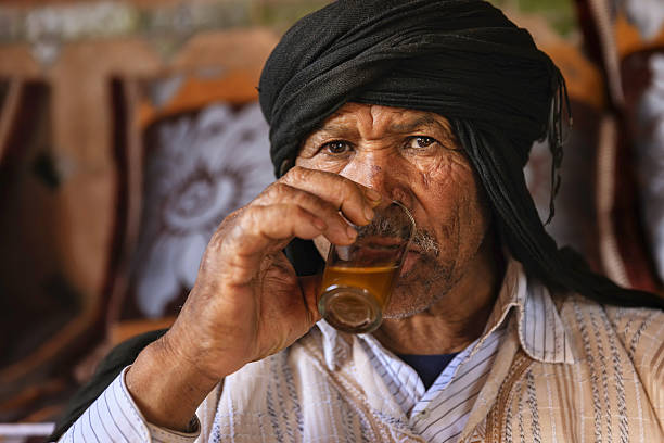 homem marroquino bebendo chá de menta maghrebi. - mint tea - fotografias e filmes do acervo