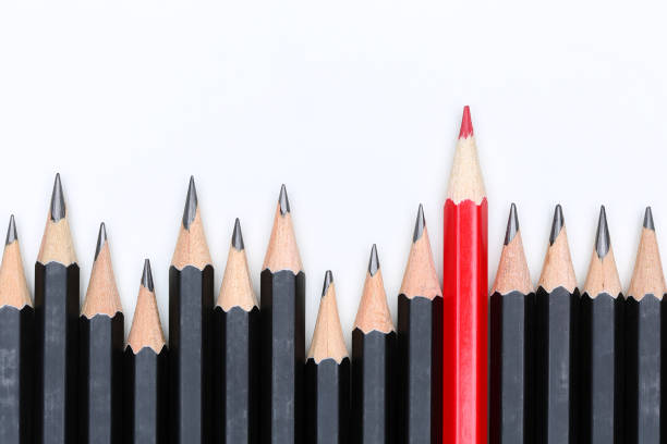 Red pencil standing out from crowd of plenty identical fellows