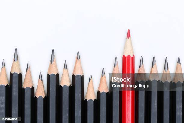Red Pencil Standing Out From Crowd Of Plenty Identical Fellows Stock Photo - Download Image Now