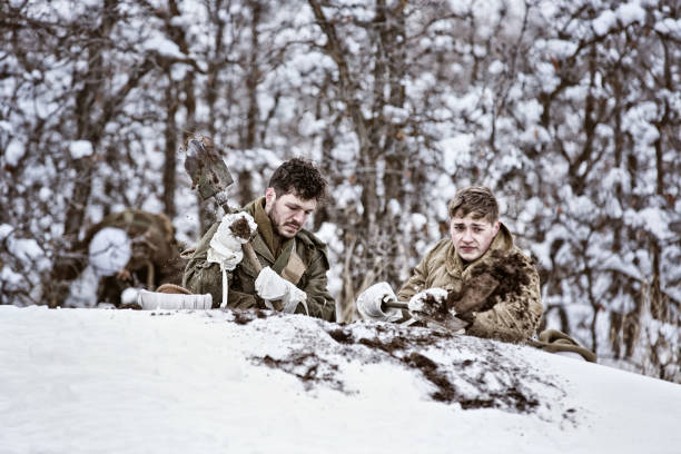 istock Two WWII US Infantry Soldiers Digging A Foxhole In Winter 639836742