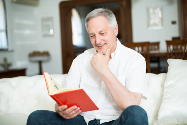 istock Happy mature man reading a book 639839482