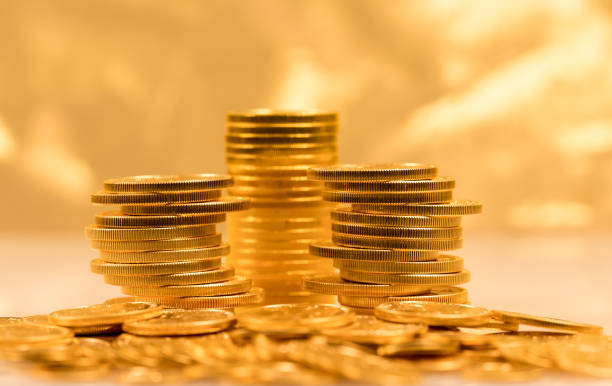 Stack of golden eagle coins Gold Eagle one ounce coins stacked into larger columns against a golden background and reflecting ounce stock pictures, royalty-free photos & images