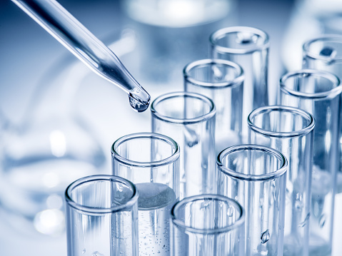 Close-up View Of Laboratory Glasswares And Tubes With Different Liquids For Scientific Research And Experiments. Modern Laboratory With Blurred Background