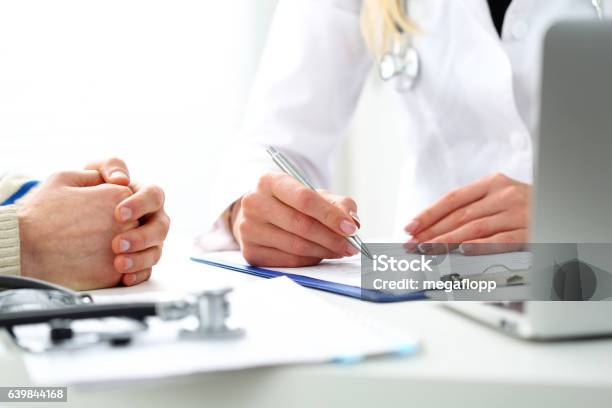 Female Doctor Hand Hold Silver Pen Filling Patient History List Stock Photo - Download Image Now