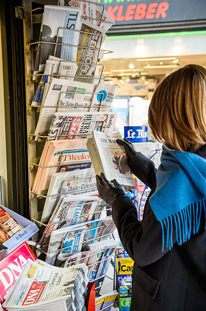 woman purchases a wall street journal newspaper from a newsstand - donald trump presidente dos estados unidos imagens e fotografias de stock