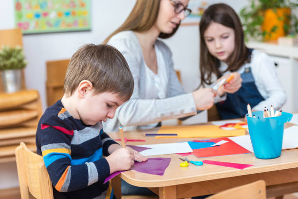 istock Preschool teacher with kids having creative activities 639858258
