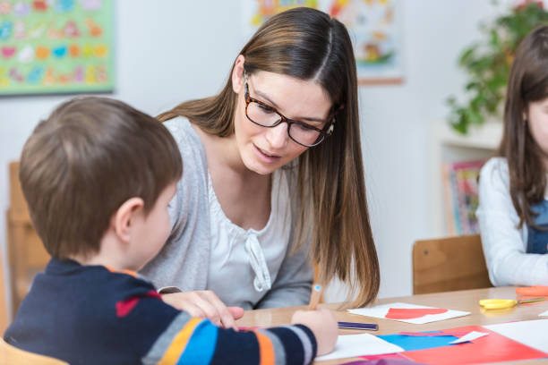 istock Preschool Taecher Gives Help To a Cute Boy 639858508