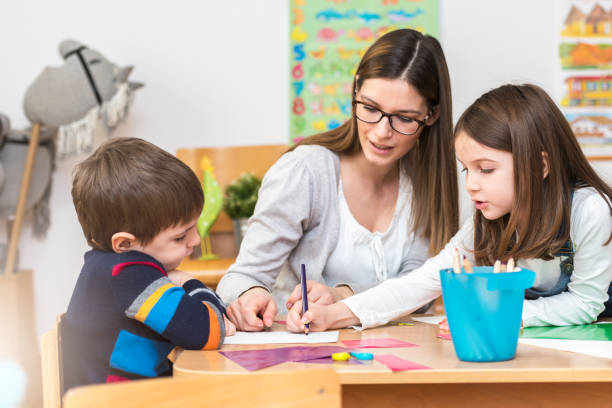 istock Preschool teacher with kids having creative activities 639858592