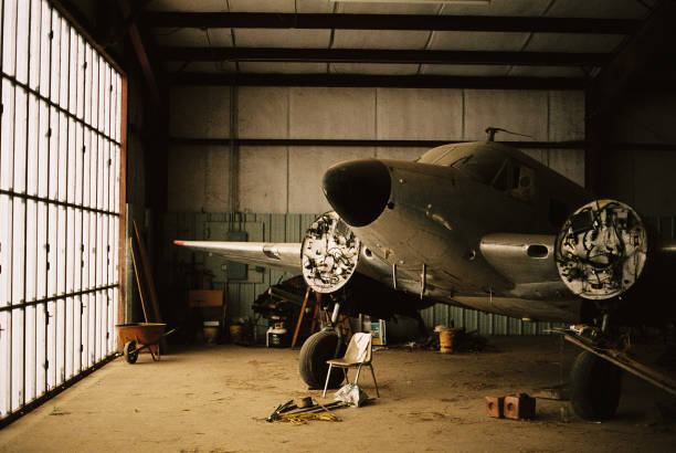 A photo of an torn down airplane in an abandoned hangar.
