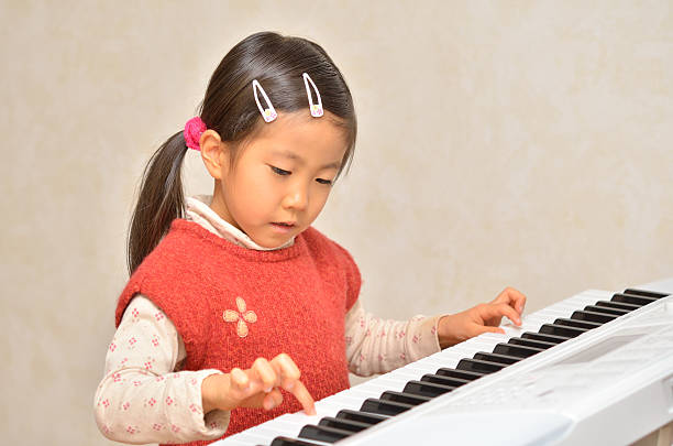 istock Japanese girl playing piano 639860056