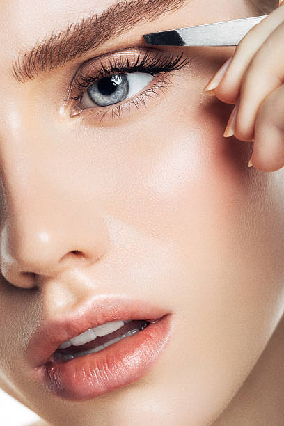Beautiful girl plucks eyebrows