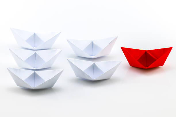 istock Leadership concept with red paper ship leading among white 639860500