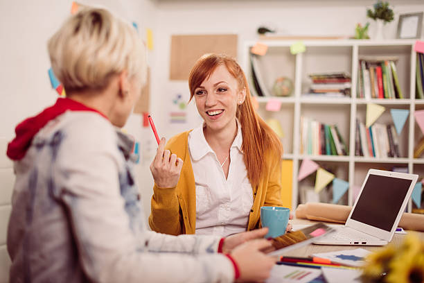 istock Female coworkers chatting in office 639863194