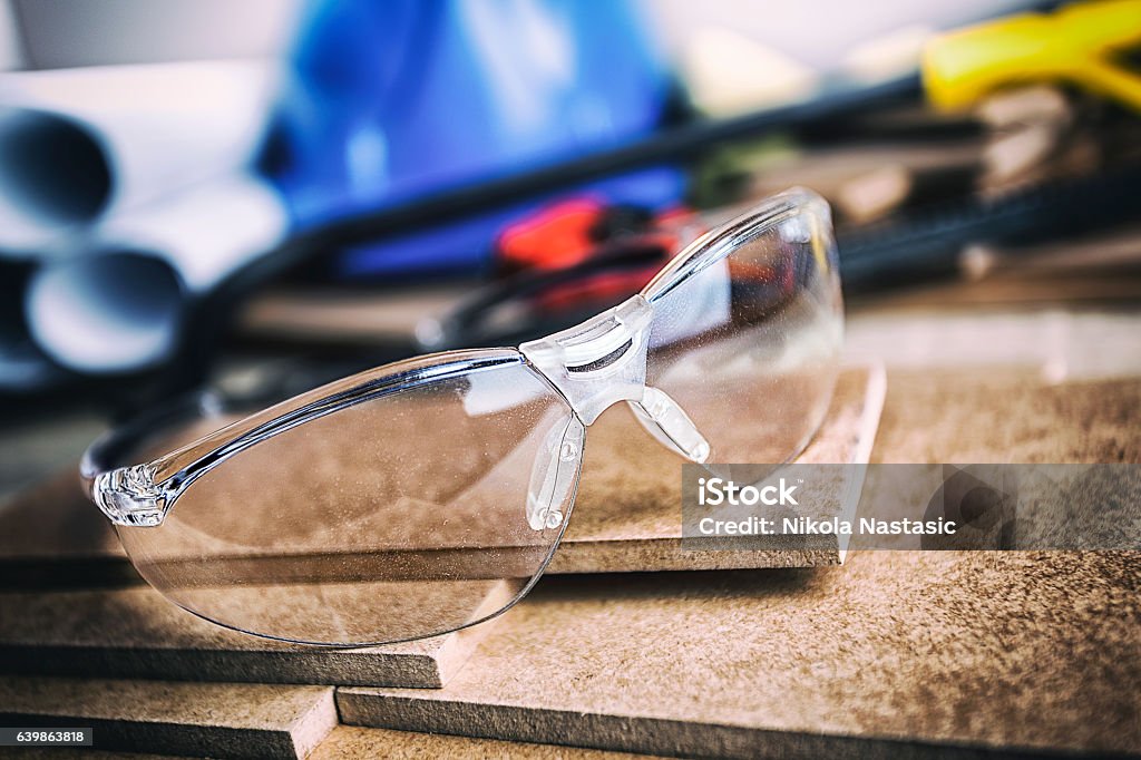 Protective glasses Protective glasses on wood planks against tools Protective Eyewear Stock Photo