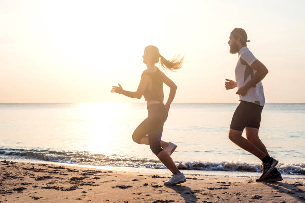 istock Running people - woman and man runners jogging on beach 639864012