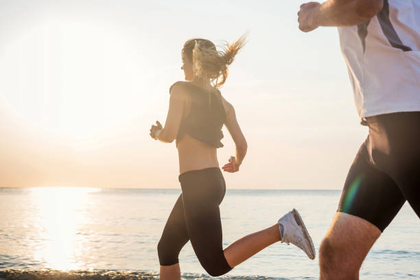 istock Running people - woman and man runners jogging on beach 639865408