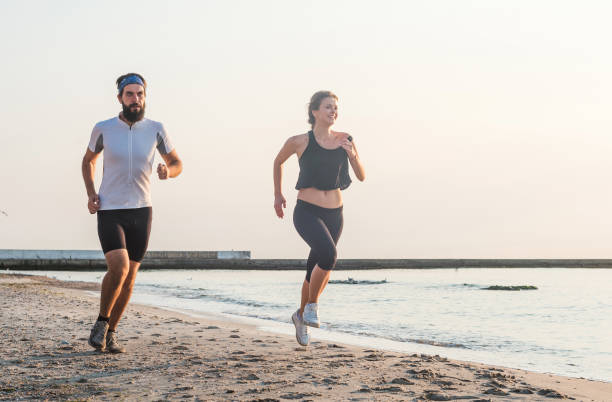 istock Running people - woman and man runners jogging on beach 639865472