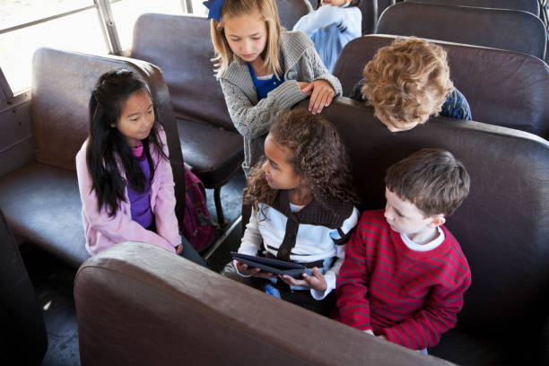 scuola bambino seduto in autobus con digital tablet - sc0536 foto e immagini stock