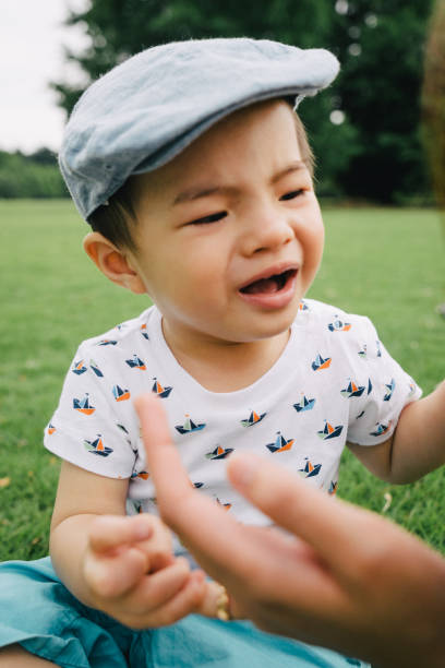 Portrait of a little child crying outdoors in a park Mother scolding her son outdoors in a park. Son crying. asian baby crying while mother scolding stock pictures, royalty-free photos & images