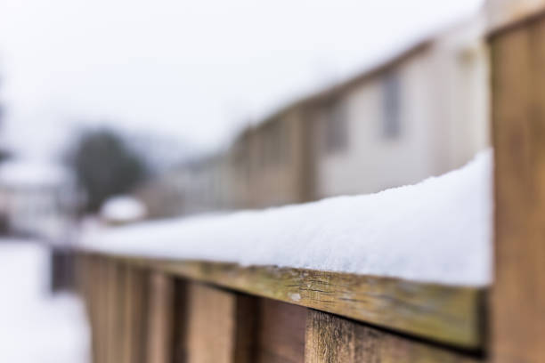 istock Heavy snow piled on fence railing in backyard 639866946