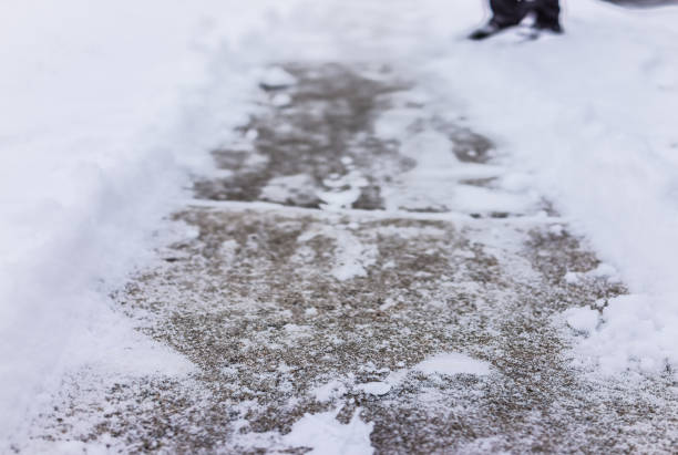 istock Sidewalk cleaned from winter snow with person's feet 639867006
