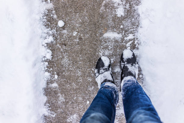 istock Sidewalk cleaned from winter snow with person's feet 639867036