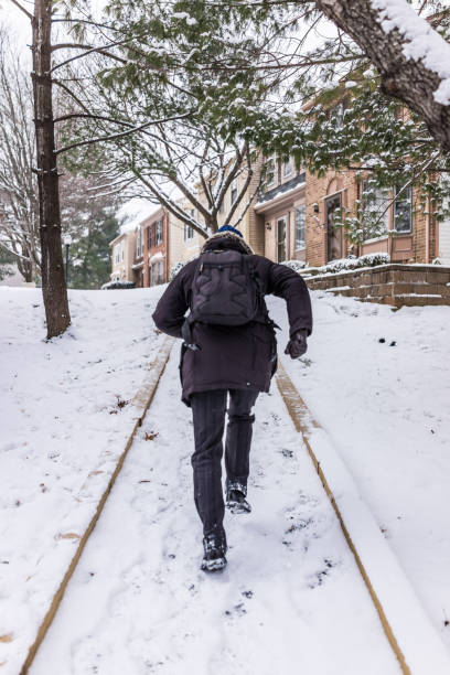 istock Man running on sidewalk covered in winter snow on hill 639867142