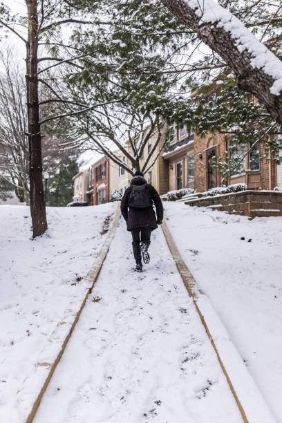 istock Man running on sidewalk covered in winter snow on hill 639867178